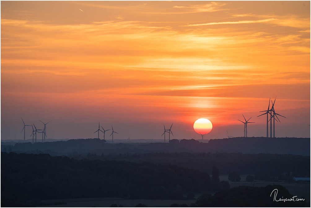 Die untergehende Sonne über den Windrädern in Richtung Holland mit 240mm Tele aufgenommen