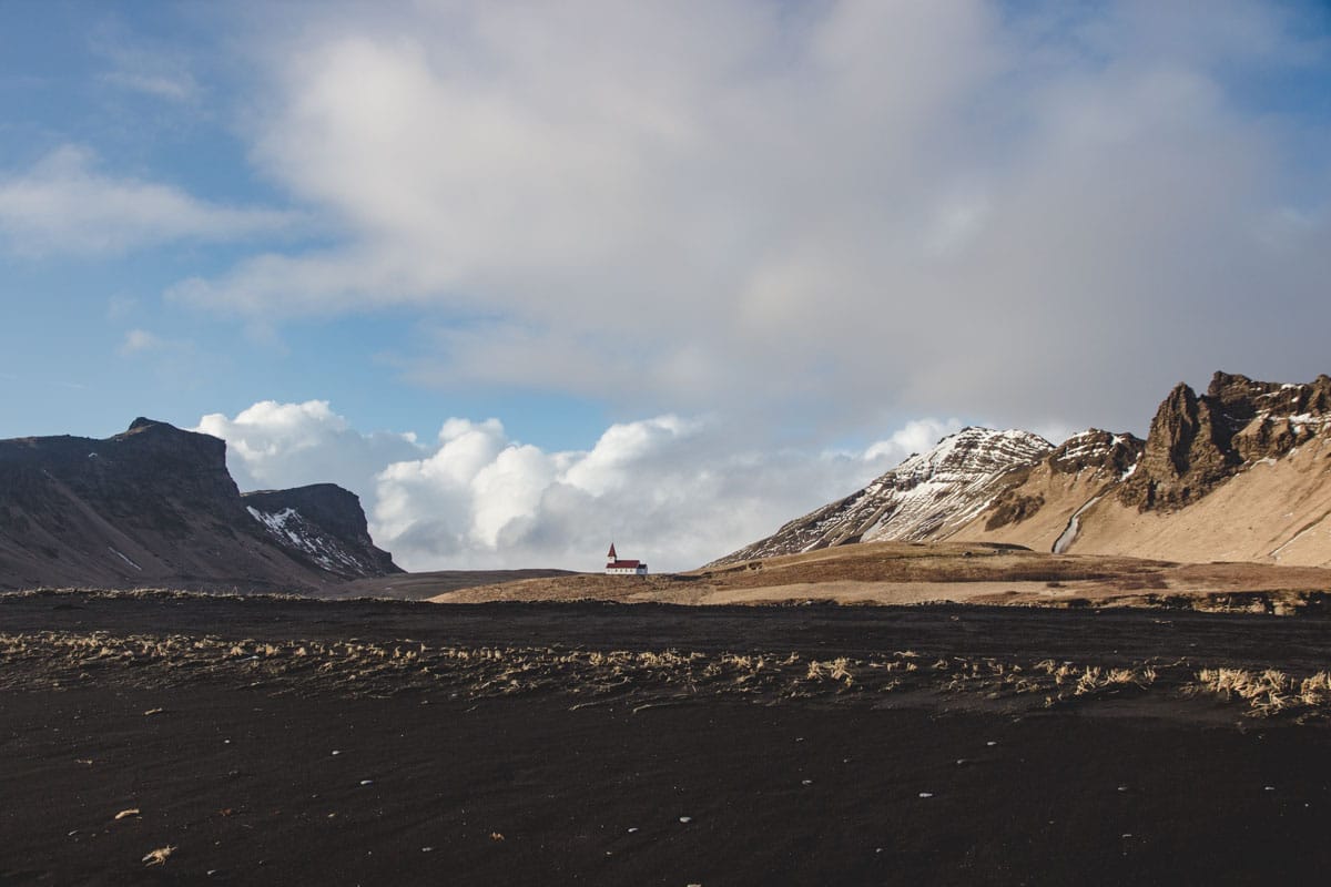 Die Kirche in Vik i Myrdal vom schwarzen Strand aus gesehen