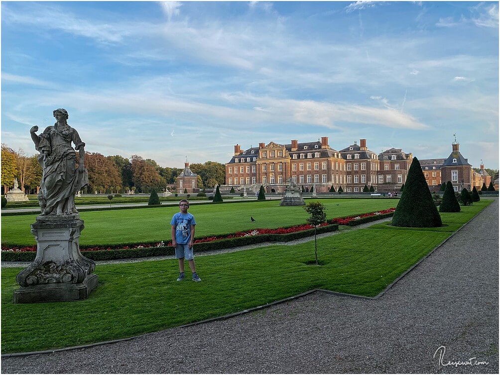 Sohnemann im Schlossgarten neben einer der Statuen