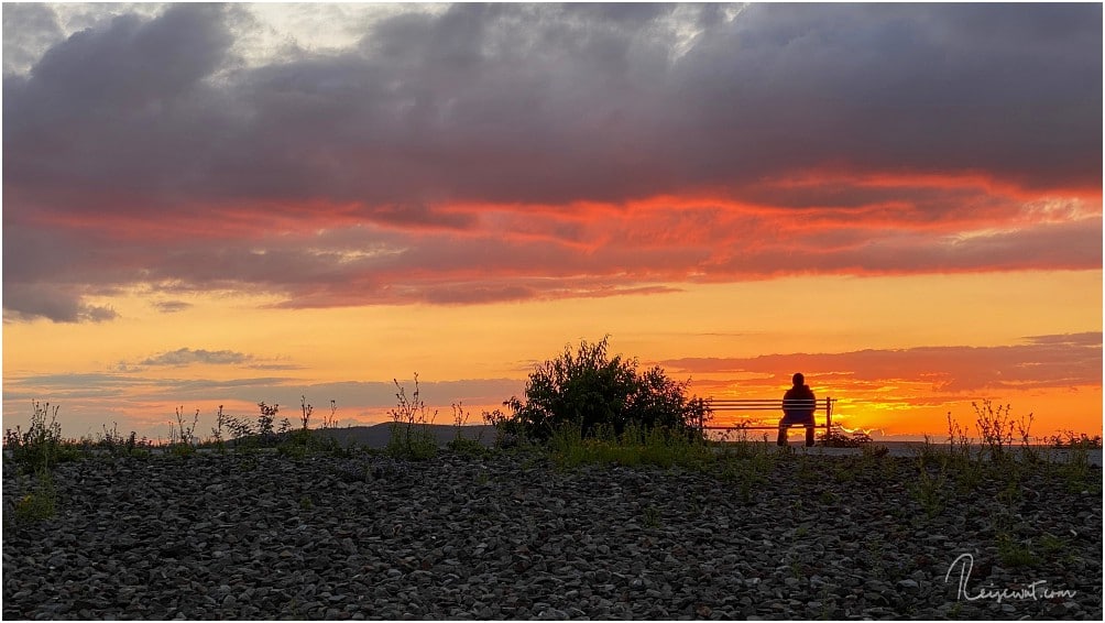Ein Sonnenuntergang zum genießen und ein zufällig dort sitzender Mann als perfektes Fotomotiv