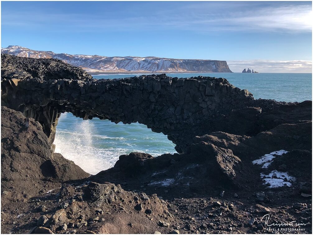 Der Arch im unteren Bereich, im Hintergrund erkennt man gut die drei Felsnadeln bei Reynisfjara