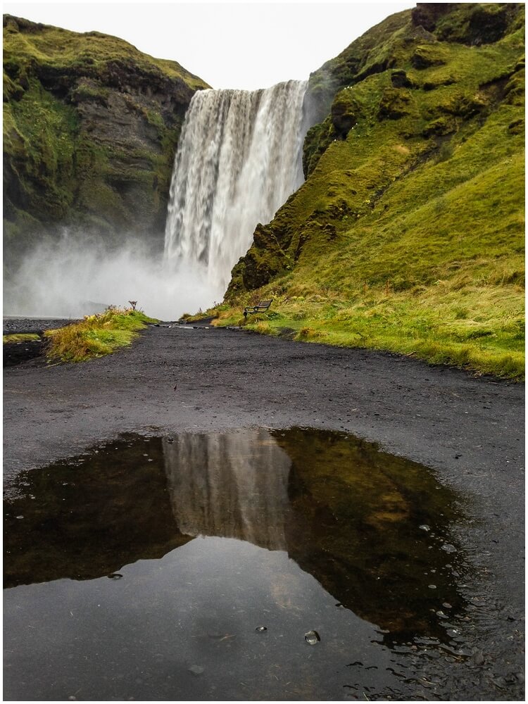 Reflektion in einer Pfütze vom Skogafoss