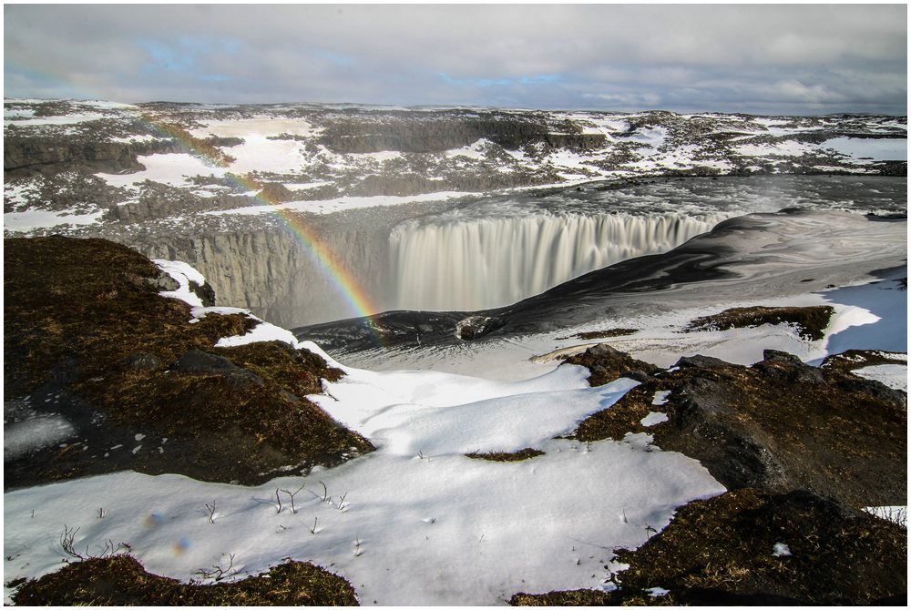 Dettifoss mit Regenbogen, der durch die gewaltige Gischt entsteht