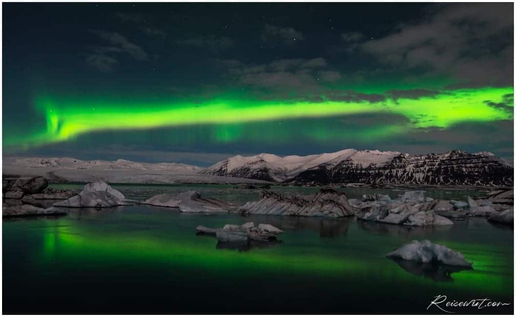 Die Polarlichter formen ein langgezogenes grünes Band 