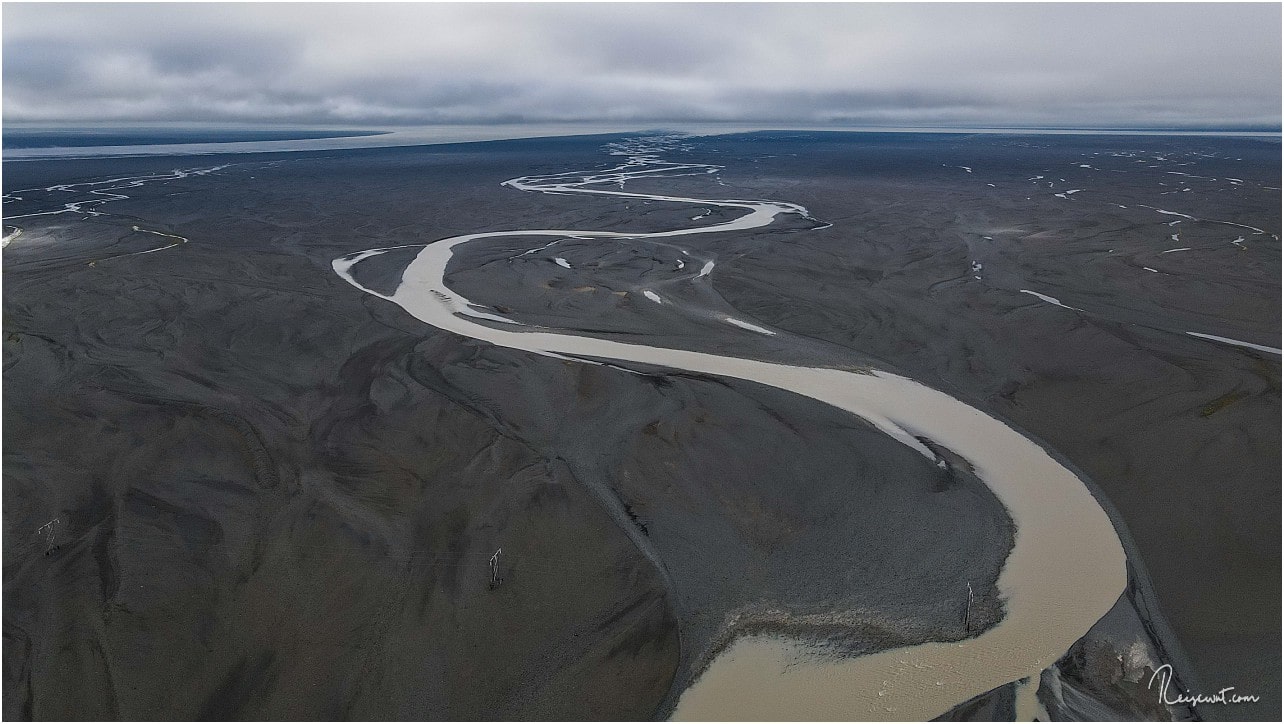 Ein Gletscherfluss sucht sich den Weg durch die Sanderfläche zum Meer