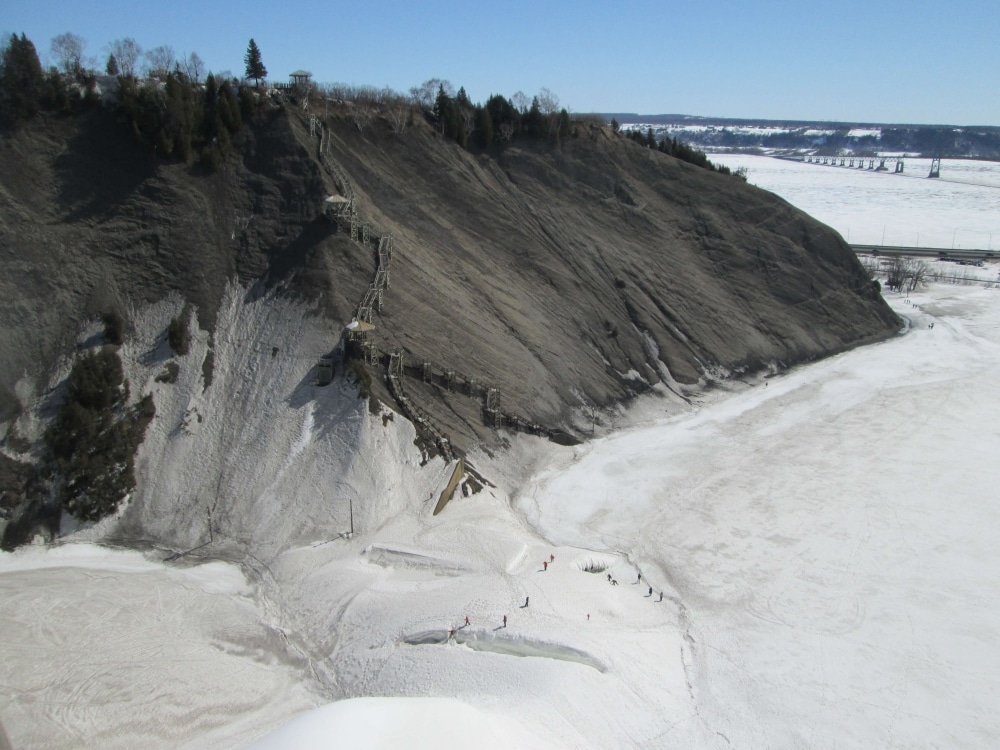 Eislandschaft Quebec - zum ersten Mal in meinem Leben hatte ich eine komplett zugefrorene Landschaft gesehen. Die Montmorency Falls und der See davor waren gefroren, ebenso der Sankt Lorenz Strom, einzig die Straße dazwischen hat das Eis quasi “unterbrochen”